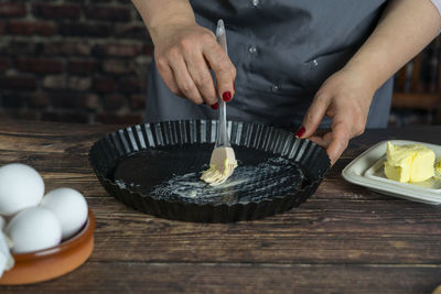 Women preparing delicious apple tart or pie.spread butter on tart plate