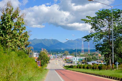 Road by trees against sky