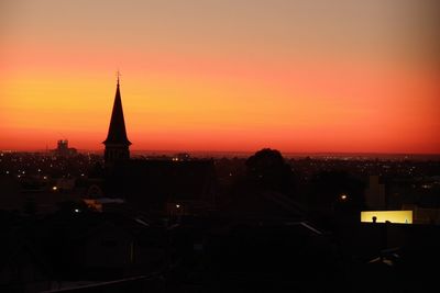 Illuminated buildings in city during sunset