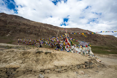Multi colored umbrellas on rock against sky