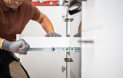 Midsection of man washing hands in bathroom