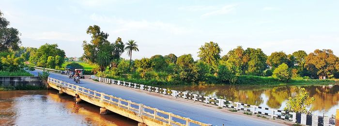 Scenic view of river by trees against sky