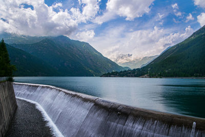 Scenic view of lake by mountains against sky