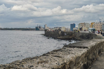 Buildings by sea against sky