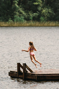 Girl jumping into lake