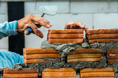 Close-up of hand building wall