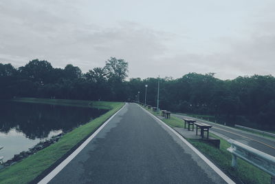 Road amidst trees against sky