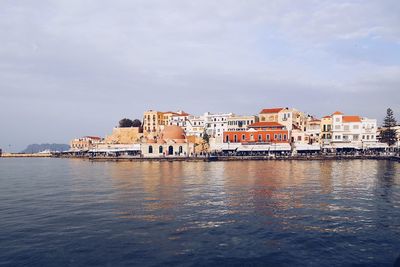 Buildings by sea against sky in city