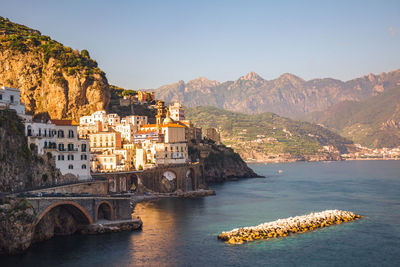 Scenic view of sea and mountains against clear sky