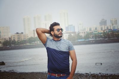 Young man standing against cityscape in city