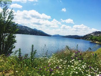Scenic view of lake by mountains against sky