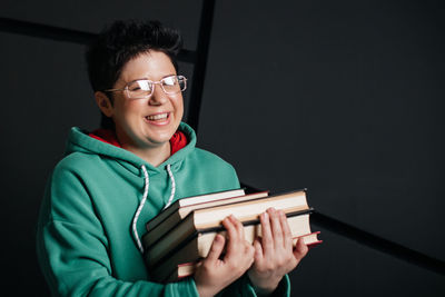 Portrait of a smiling young man holding book