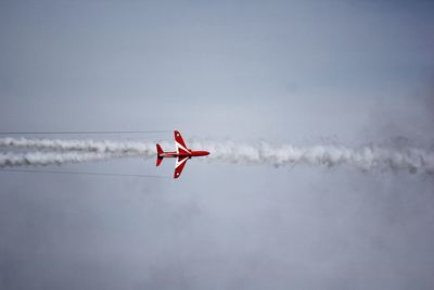 A single red arrow creating vapor trails