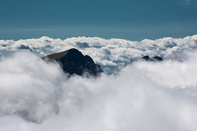 Scenic view of clouds covering mountains against sky