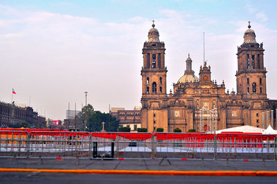 View of buildings in city against cloudy sky