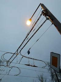 Low angle view of illuminated street light against sky