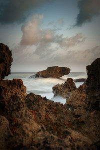 Scenic view of rocks on beach against sky