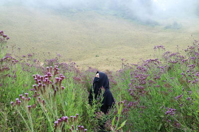 Rear view of person standing on field