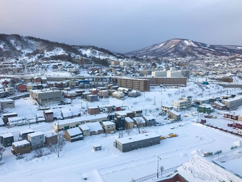 High angle view of snow covered houses in city