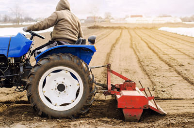 Farmer on a tractor with milling machine loosens, grinds and mixes soil. loosening the surface