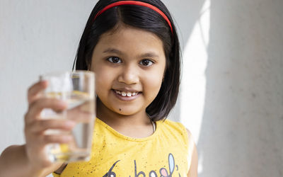 Portrait of a smiling young woman drinking glass