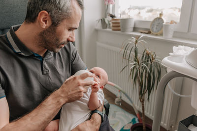 Father feeding baby with bottle of baby formula