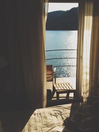 Empty bench at hotel by sea on sunny day