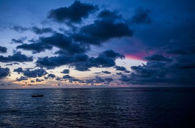 Scenic view of sea against cloudy sky at sunset