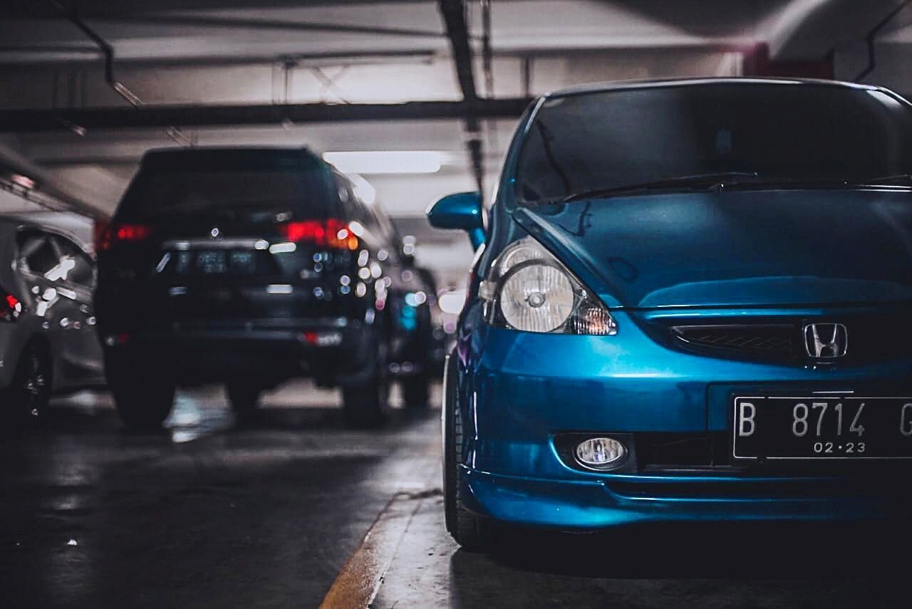 mode of transportation, transportation, car, motor vehicle, land vehicle, focus on foreground, indoors, blue, day, close-up, no people, headlight, auto repair shop, vehicle hood, city, shopping, parking lot, street, garage, consumerism