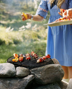 Woman barbecuing kebabs