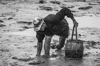 Man working in mud at beach