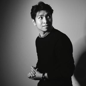 Portrait of young man standing against white background