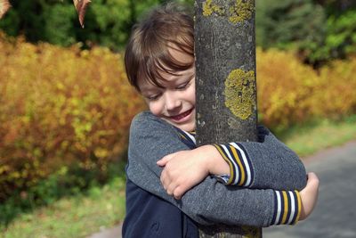 Full length of smiling boy in park during autumn