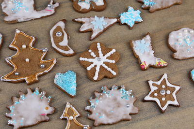 High angle view of various gingerbread cookies on wooden table