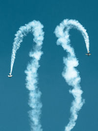 Low angle view of airplane flying against blue sky