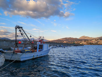 Fishing boats in sea against sky