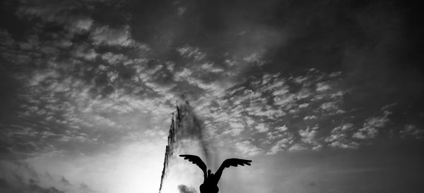 Low angle view of silhouette birds flying against sky