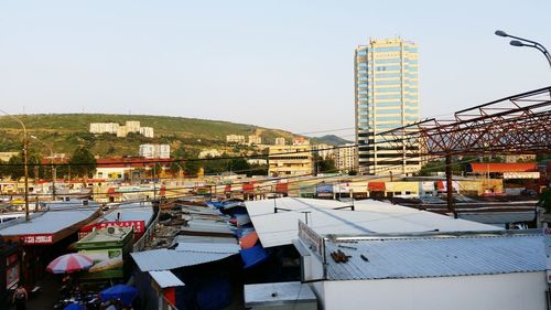 Boats moored in city against clear sky