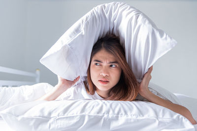 Portrait of young woman sleeping on bed at home