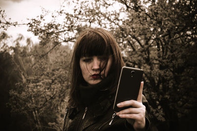 Woman using mobile phone in forest