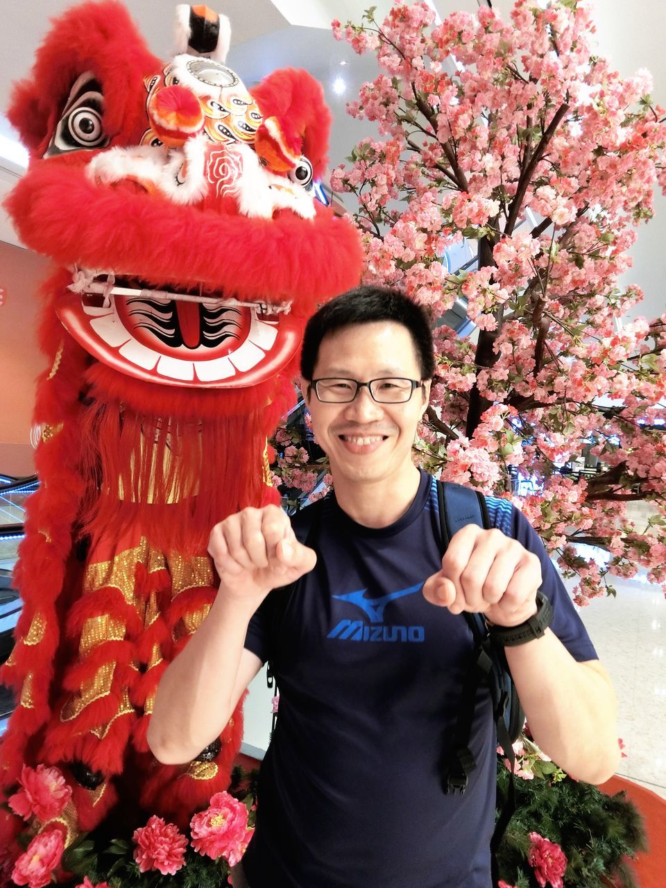 looking at camera, real people, smiling, two people, chinese new year, celebration, portrait, cultures, young adult, front view, leisure activity, traditional festival, lifestyles, happiness, day, men, red, outdoors, young women, tree, cheerful, women, togetherness, chinese dragon, adult, people