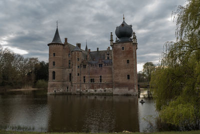 Historic building by lake against sky