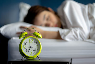 Portrait of young woman sleeping on bed at home