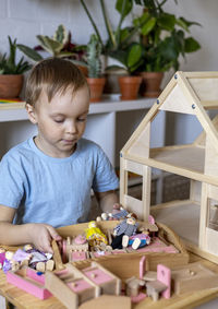 Boy playing with wooden toy at home