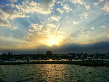 Scenic view of sea against cloudy sky during sunset