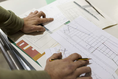 Male carpenter with paperwork at workbench in industry