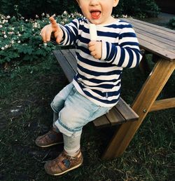 Low section of boy eating ice cream on field