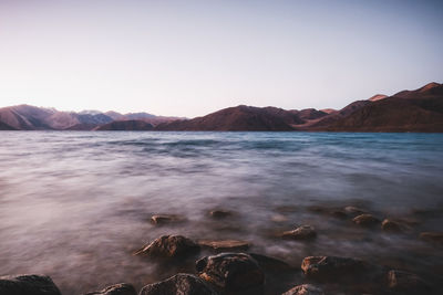 Scenic view of sea and mountains against sky