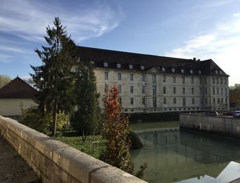 Building by canal against sky