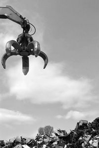 Low angle view of padlocks hanging against sky